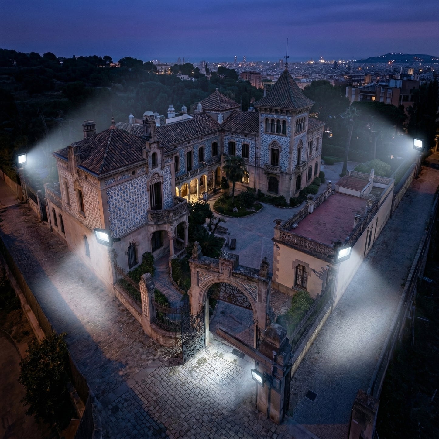 Large, ornate building at night with illuminated pathways and surrounding cityscape.