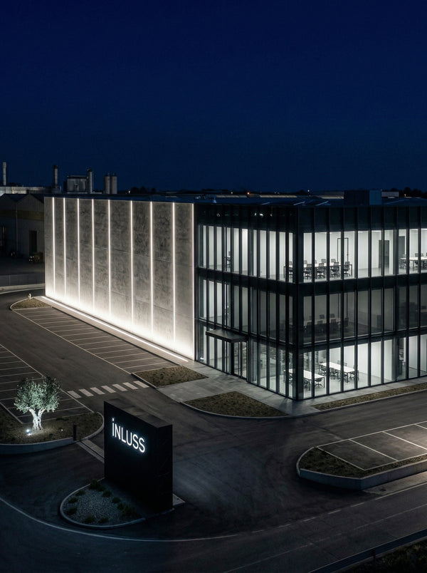 INLuss building with illuminated facade at night.